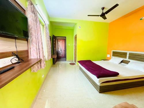 a bedroom with yellow and green walls and a bed at Hotel Falcon House ! Puri in Puri