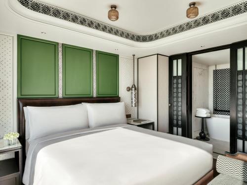 a bedroom with a white bed and green walls at InterContinental Chiang Mai The Mae Ping in Chiang Mai
