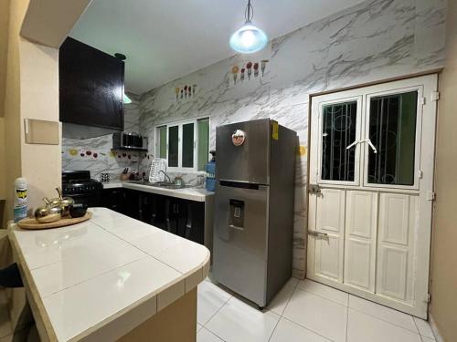 Il comprend une cuisine équipée d'un réfrigérateur en acier inoxydable et d'un comptoir. dans l'établissement La Casa del Zoomat, à Tuxtla Gutiérrez