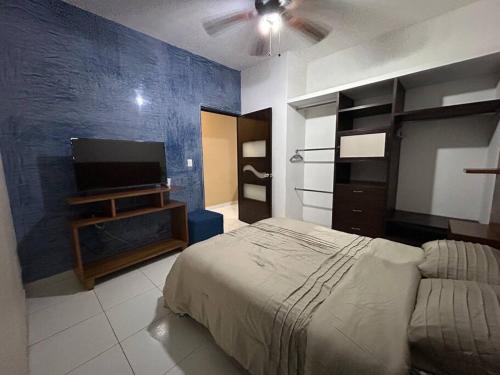 Schlafzimmer mit einem Bett und einem Flachbild-TV in der Unterkunft La Casa del Zoomat in Tuxtla Gutiérrez