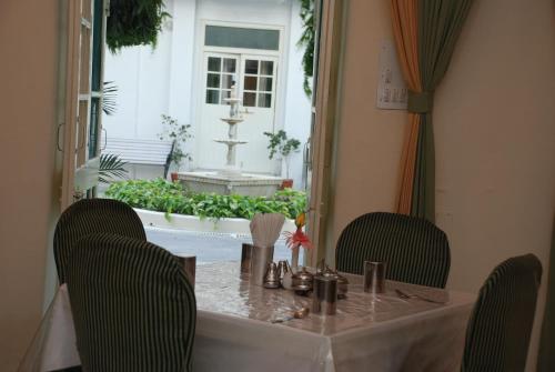 a table with two chairs and a table and a window at Garden Hotel - Heritage by HRH Group of Hotels in Udaipur