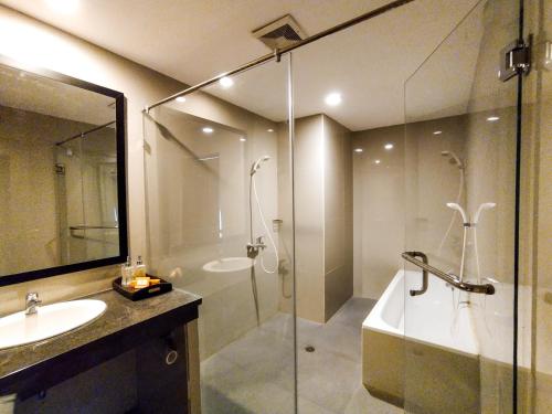 y baño con ducha, bañera y lavamanos. en Green Hayaq Hotel, en Selong