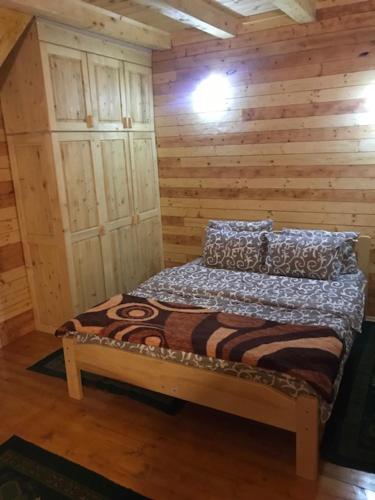 a bed in a room with a wooden wall at Holiday Home JASEN in Kolašin