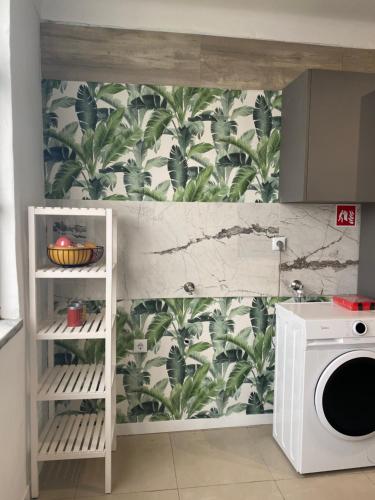 a kitchen with a wall with a plant wallpaper at Elegance to close from Lisbon! in Montijo