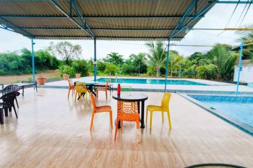 a patio with tables and chairs next to a pool at Mumbai Oasis in Thane