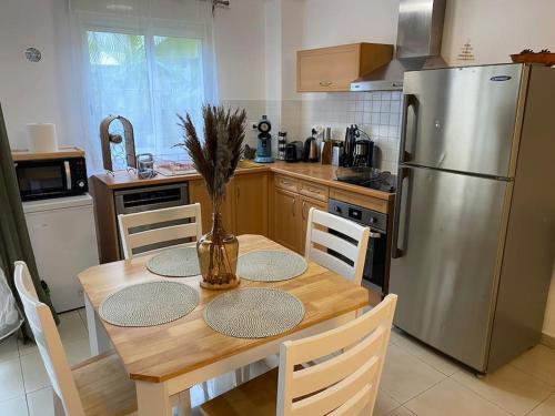 a kitchen with a wooden table and a stainless steel refrigerator at F2 St Denis Jardin d'état in Saint-Denis