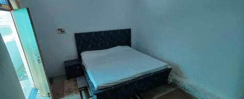 ein kleines Schlafzimmer mit einem kleinen Bett in einem Zimmer in der Unterkunft OYO Gopal Hotel And Family Restaurant in Gwalior