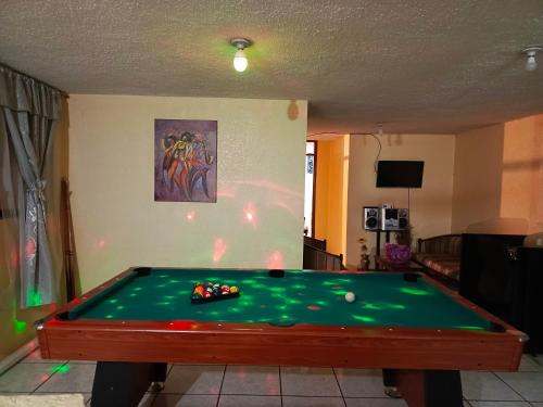 a pool table in a living room with at Casa relax in Quito
