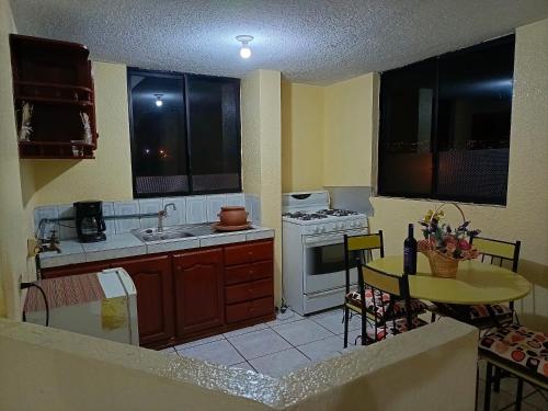 a kitchen with a sink and a stove top oven at Casa relax in Quito