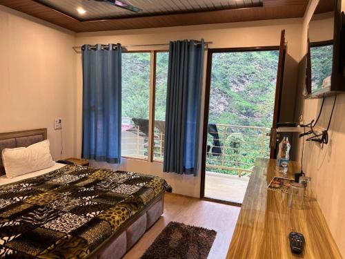 - une chambre avec un lit et une grande fenêtre dans l'établissement Kedar Valley Resorts Kedarnath, à Phata