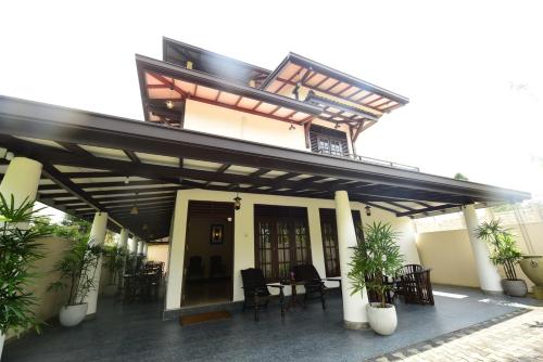 a building with a patio with tables and chairs at Kurulu Villa Baddegama in Galle