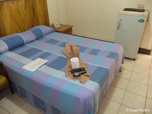 a hotel room with a bed with a remote control at 2 Hotel Saleh in Angeles