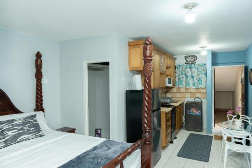 a bedroom with a bed and a small kitchen at Finest Accommodation Oxford Manor One Bedroom Apt # 27 in Kingston