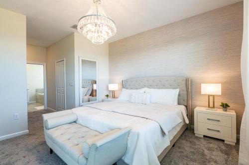 a bedroom with a large white bed and a chandelier at Top Villas - Championsgate 1713 in Kissimmee