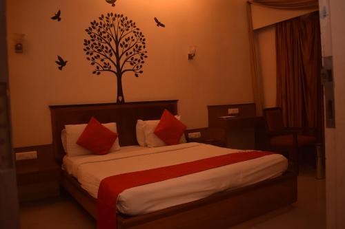 1 dormitorio con 1 cama con un árbol en la pared en HOTEL DHIRAJ, en Thane