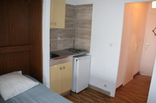 une petite cuisine avec un évier et une cuisinière dans l'établissement Studio 34, Héliopolis FGH, Village naturiste, au Cap d'Agde