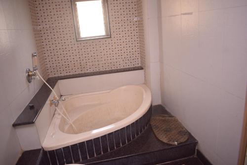 e bagno con finestra e vasca. di HOTEL DHIRAJ a Thane