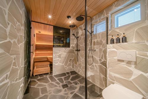 ein Bad mit einer Dusche und einer ebenerdigen Dusche in der Unterkunft Villa Alvo in Kittilä