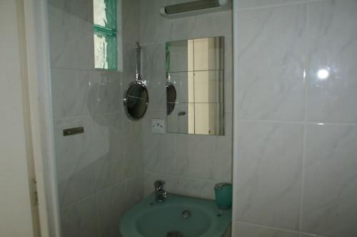 une salle de bain avec un lavabo et un miroir dans l'établissement Studio 46, Héliopolis FGH au village naturiste, au Cap d'Agde