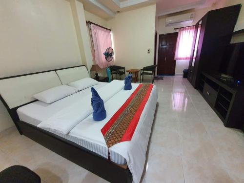 um quarto com uma cama grande e almofadas azuis em Kasithorn Apartment&Hotel em Phetchabun