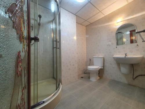 een badkamer met een douche, een toilet en een wastafel bij Kasithorn Apartment&Hotel in Phetchabun