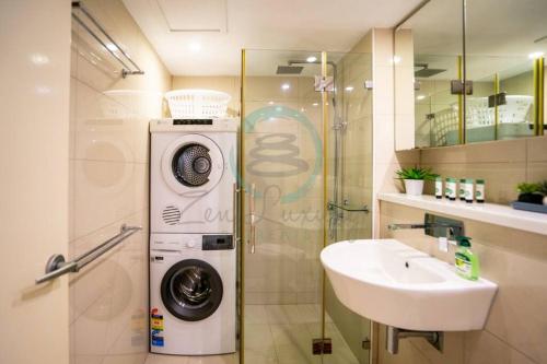 a bathroom with a washing machine and a sink at Zen Ocean Pebble 1-BR/1-BA Sea View Retreat in Darwin