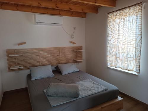 Schlafzimmer mit einem großen Bett und einem Fenster in der Unterkunft בריזה במדבר in Idan