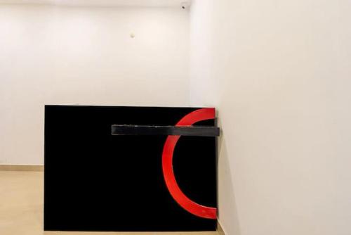 a black and red painting on a white wall at Golden Avenue in Trivandrum