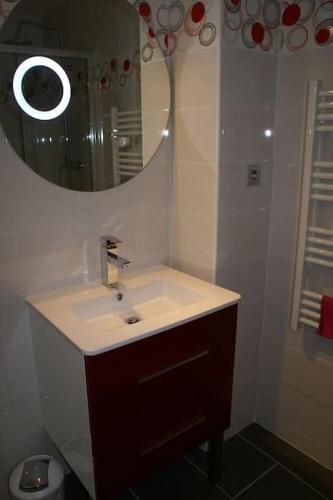 ein Bad mit einem Waschbecken und einem Spiegel in der Unterkunft Studio 14, Héliopolis J village naturiste in Cap d'Agde