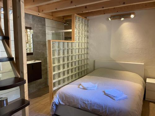 a bedroom with a bed with towels on it at La Gardette in Le Freney-dʼOisans