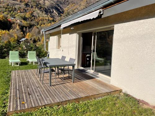 une table et des chaises sur une terrasse à côté d'une maison dans l'établissement La Gardette, à Le Freney-dʼOisans
