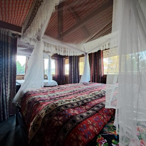 a bedroom with a bed with a canopy at Homestay field - bungalow, Ha giang loop tour, motorbikes rental in Ha Giang