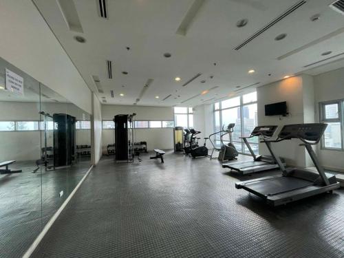 um ginásio com equipamento cardiovascular numa sala grande em 1 Bedroom Condo with Balcony in Ermita near the US Embassy and PGH em Manilla