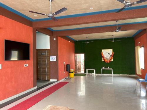 a large room with red walls and a flat screen tv at Prem Bhawan Guest House in Khātu