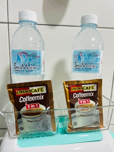 two bottles of sesame water and two containers of food in a refrigerator at JC Homestay Gamuda Skyluge KL 2 in Rawang