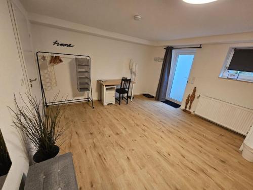 una sala de estar vacía con escritorio y silla en Apartment Tanne, en Düsseldorf