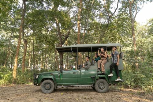 a group of people riding in a green jeep at Kasara Chitwan in Chitwan