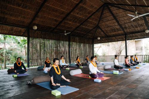 a group of people sitting in a yoga class at Kasara Chitwan in Chitwan