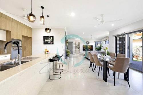 a kitchen and dining room with a table and chairs at Zenhouse Vista Elegant 5BR Coastal Haven in Leanyer
