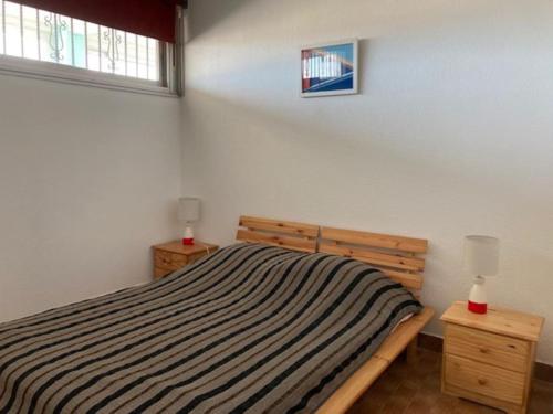 - une chambre avec un lit rayé et une fenêtre dans l'établissement Appartement 308, Héliopolis K, au Cap d'Agde