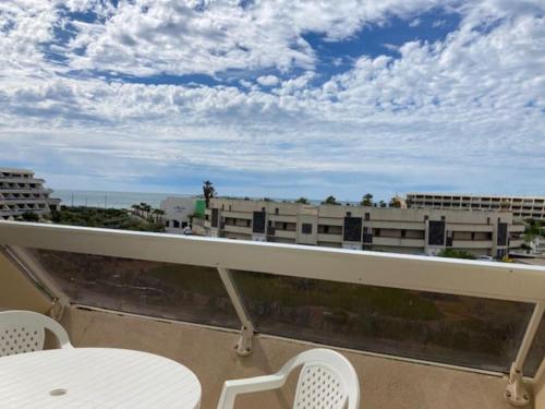 d'un balcon avec une table et des chaises offrant une vue sur la ville. dans l'établissement Appartement 308, Héliopolis K, au Cap d'Agde