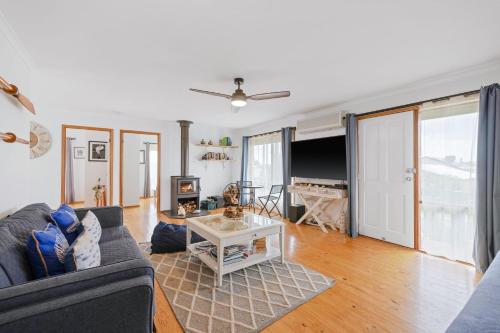 a living room with a couch and a table at Old Sea Dog's Retreat in Coronet Bay