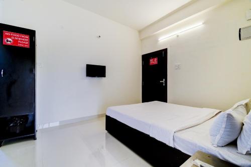 a bedroom with a bed and a red sign on the wall at OYO Home Cozy Home in Guwahati