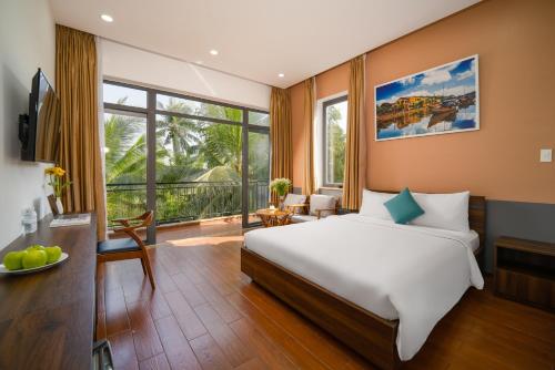 een slaapkamer met een bed en een groot raam bij RAON Boutique Villa in Hội An