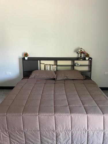 1 dormitorio con 1 cama grande y edredón marrón en Chambre d'hôte chez pat & nat - Thailande authentique en Chaiyaphum