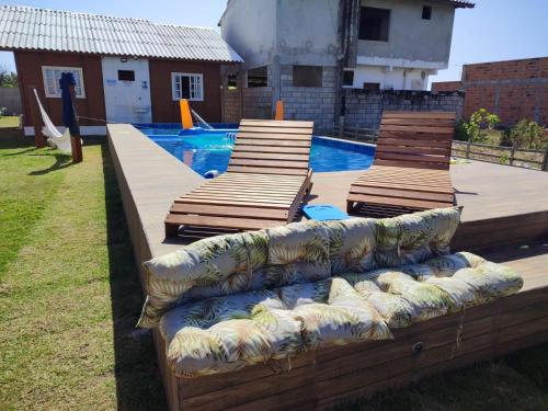three chaise lounges sitting next to a swimming pool at Recanto Arvoredo in Entre Rios