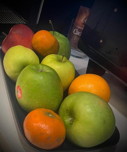 a bowl of fruit with apples oranges at Auberge La Veranda in Luxembourg