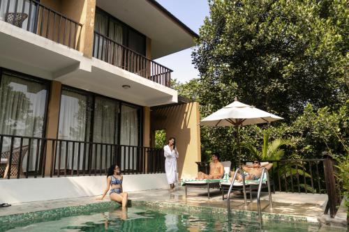 a group of people in the swimming pool of a villa at Kasara Chitwan in Chitwan