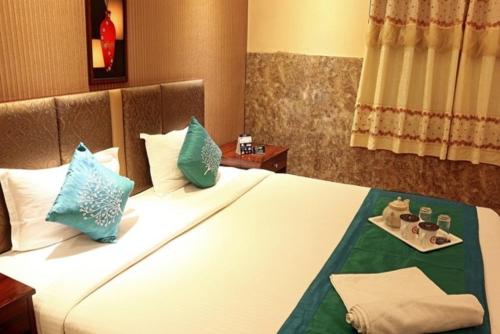 a hotel room with a large bed with blue pillows at SHREE KRISHNA HOTELS & RESORTS PVT LTD in Salua
