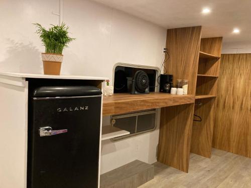a kitchen with a black refrigerator and a counter at Camper with A/C - Glamping 3 Idiomas in El Sargento